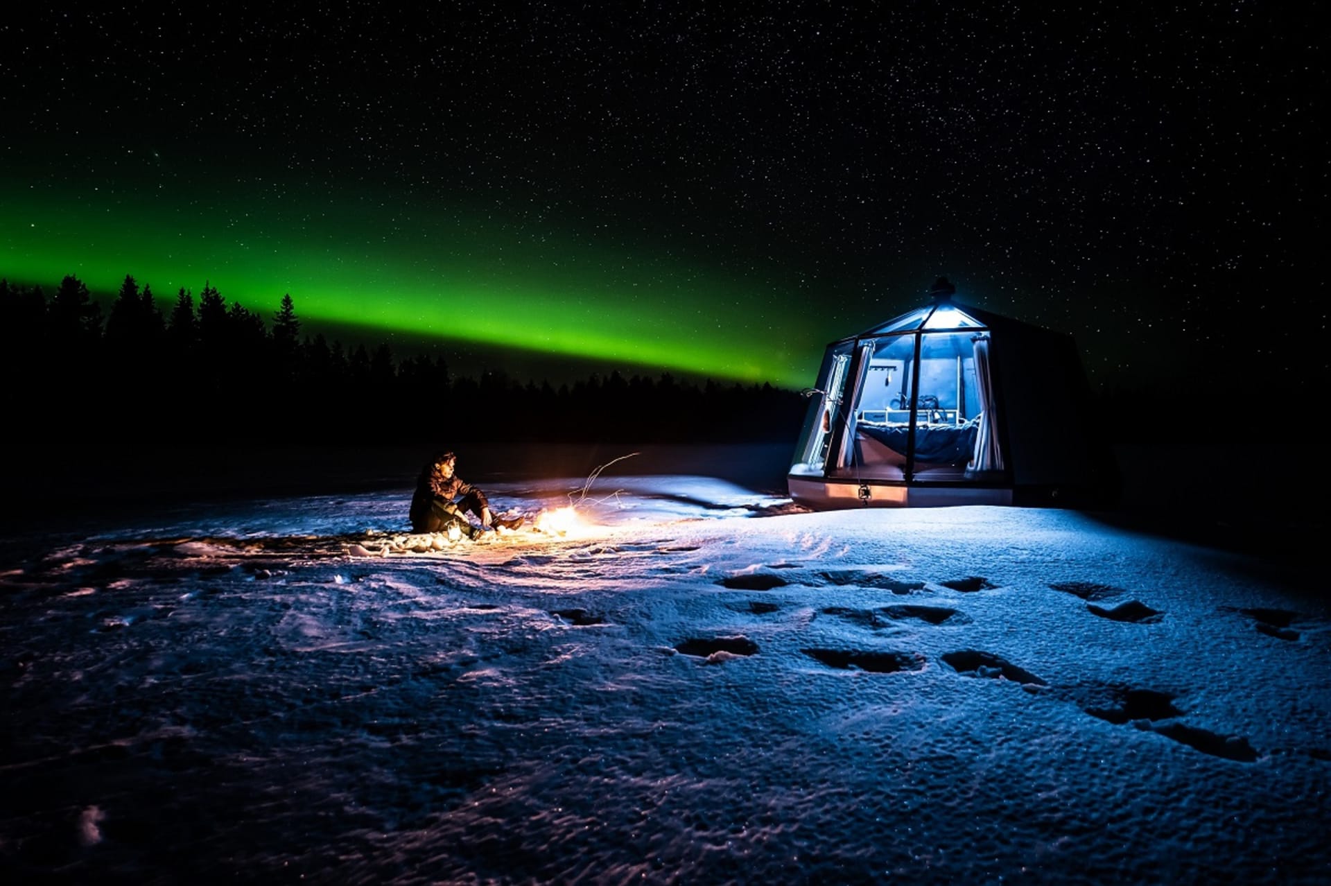 Northern lights and one of our AuroraHut glass igloos at lake Ranuanjärvi in Ranua, Finnish Lapland.